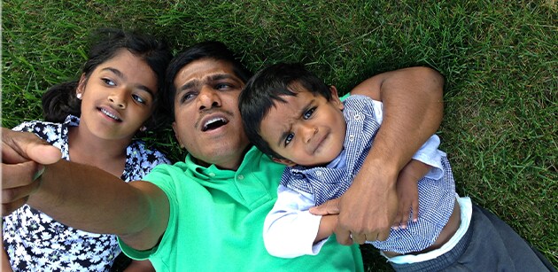 Venkat lying in the grass with his children Venkat lying in the grass with his children