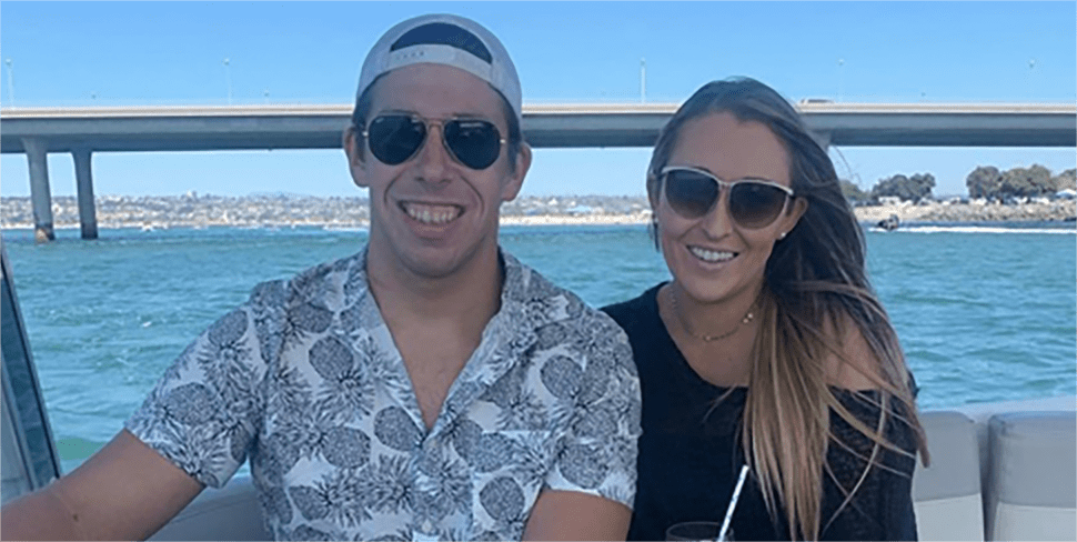 Brandon outside on a boat with a woman by his side