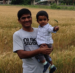 Venkat holding his son in a field